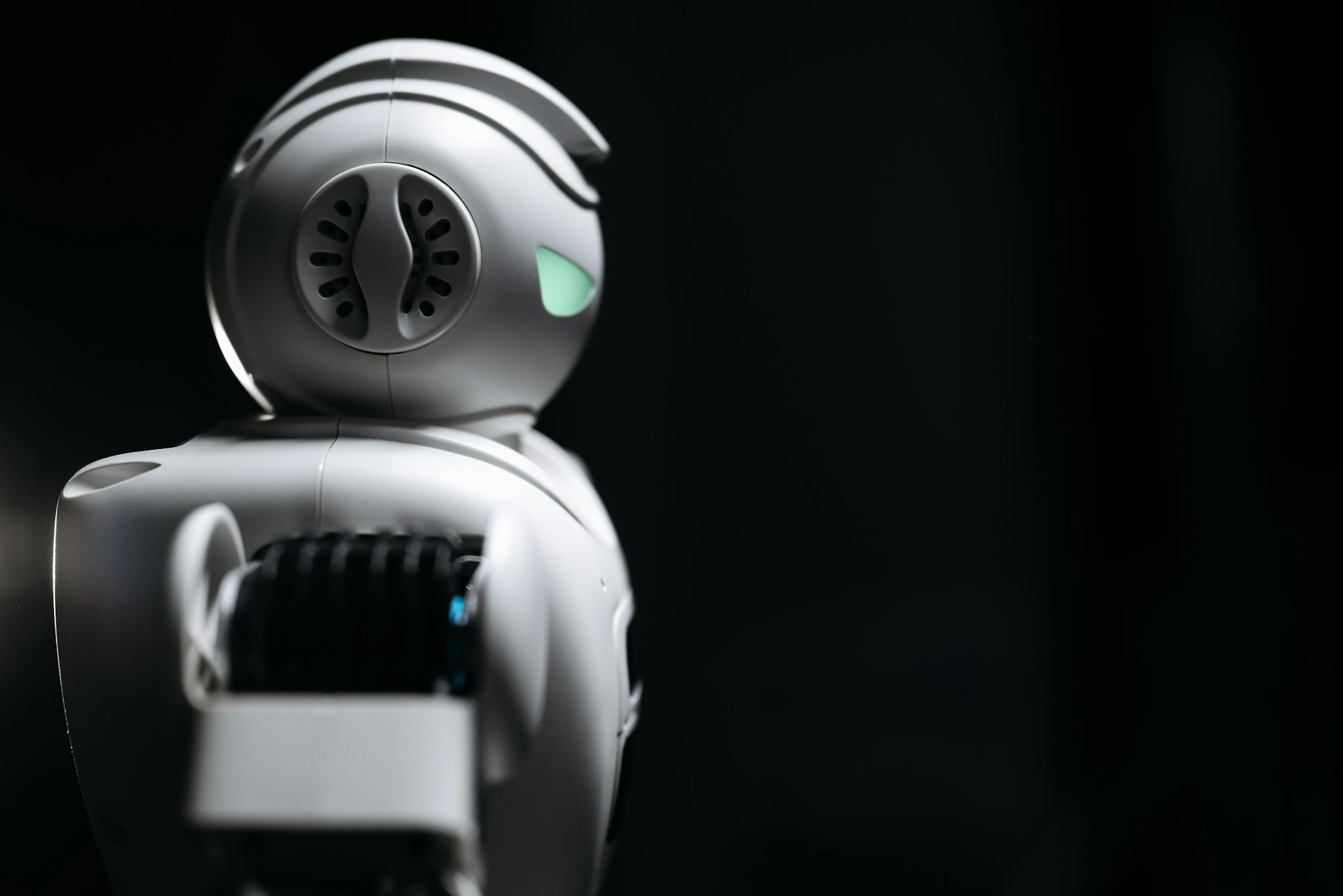 Close-up of a futuristic robot in a dark studio setting, showcasing innovation and technology.